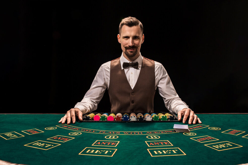 Portrait,Of,A,Croupier,Is,Holding,Playing,Cards,,Gambling,Chips