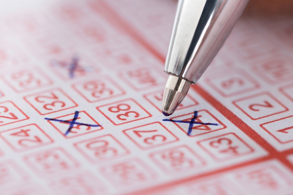 Close up,Of,Person's,Hand,Marking,Number,On,Lottery,Ticket,With