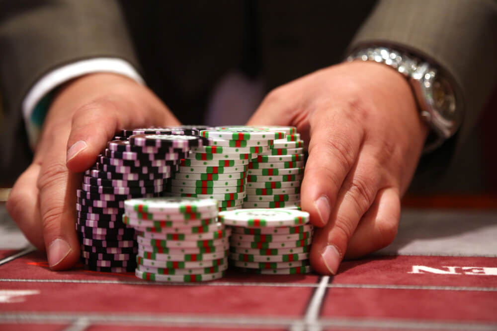 Player,At,Gambling,Table,Pusing,Large,Stack,Of,Chips
